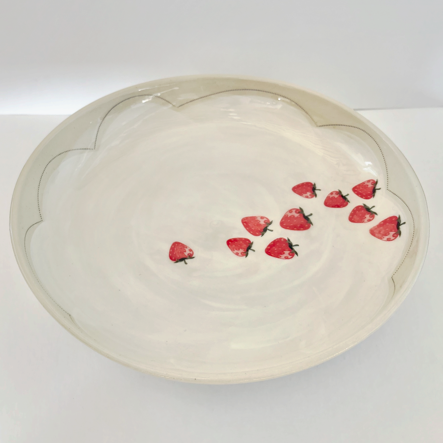 White serving platter with red strawberry patterns on a white background