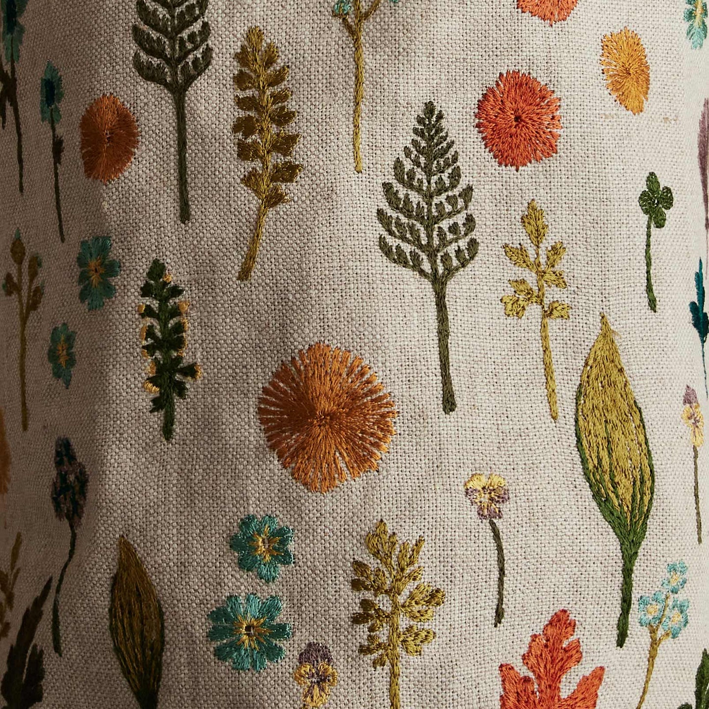 Coral and Tusk’s “Garden” embroidered linen bucket bag featuring a pattern of florals and greenery