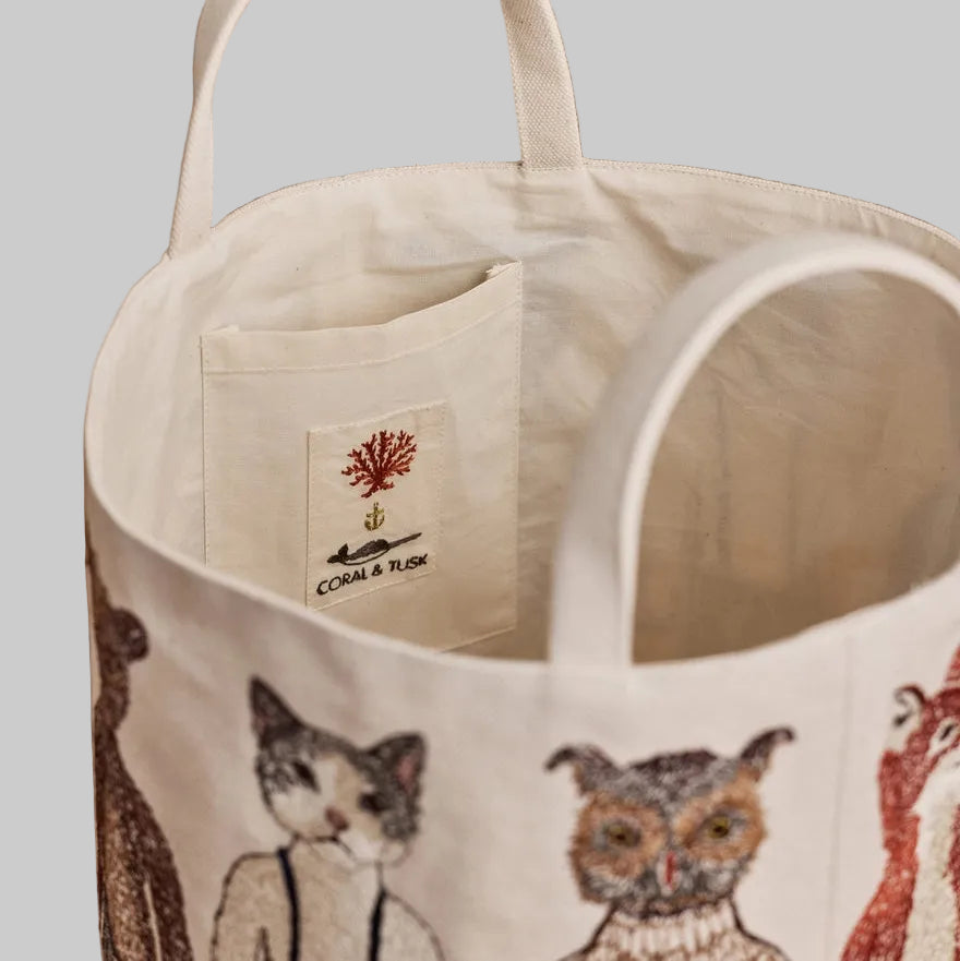 Coral and Tusk's "Pocket Doll" canvas bucket bag featuring embroidered designs of animal friends in fanciful clothing