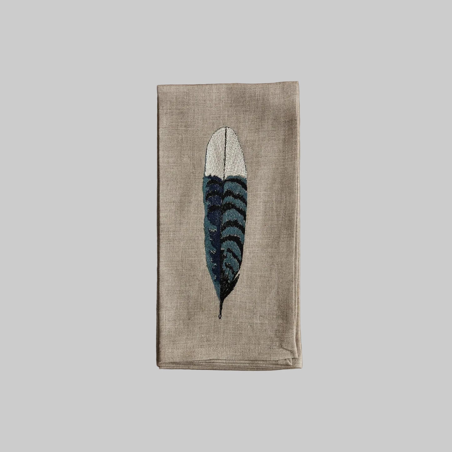 Coral and Tusk’s “Blue Jay Feather” embroidered linen dinner napkin