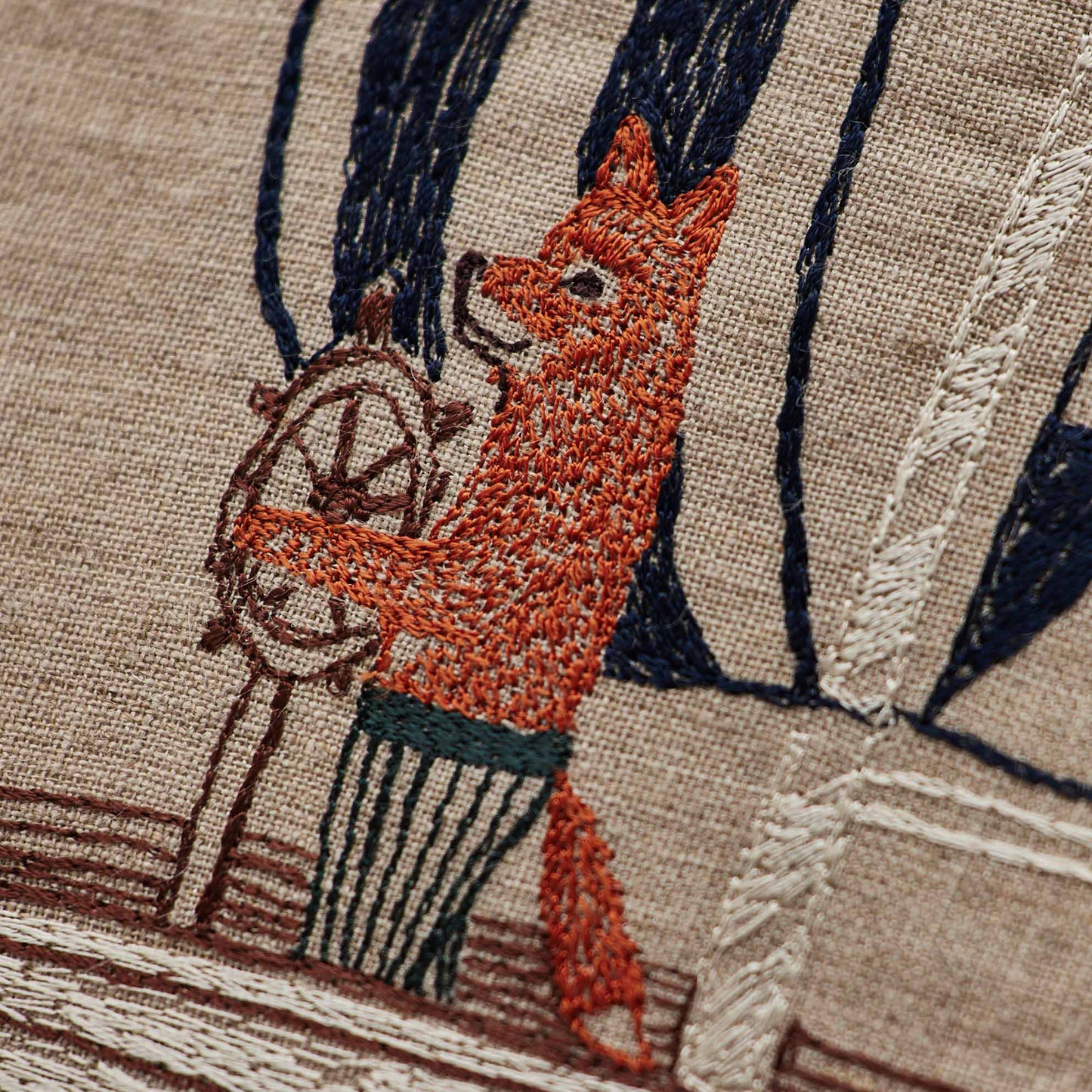 Coral and Tusk’s “Sailing Foxes” embroidered linen pillow featuring two foxes on a sailboat, measures 12” x 12”