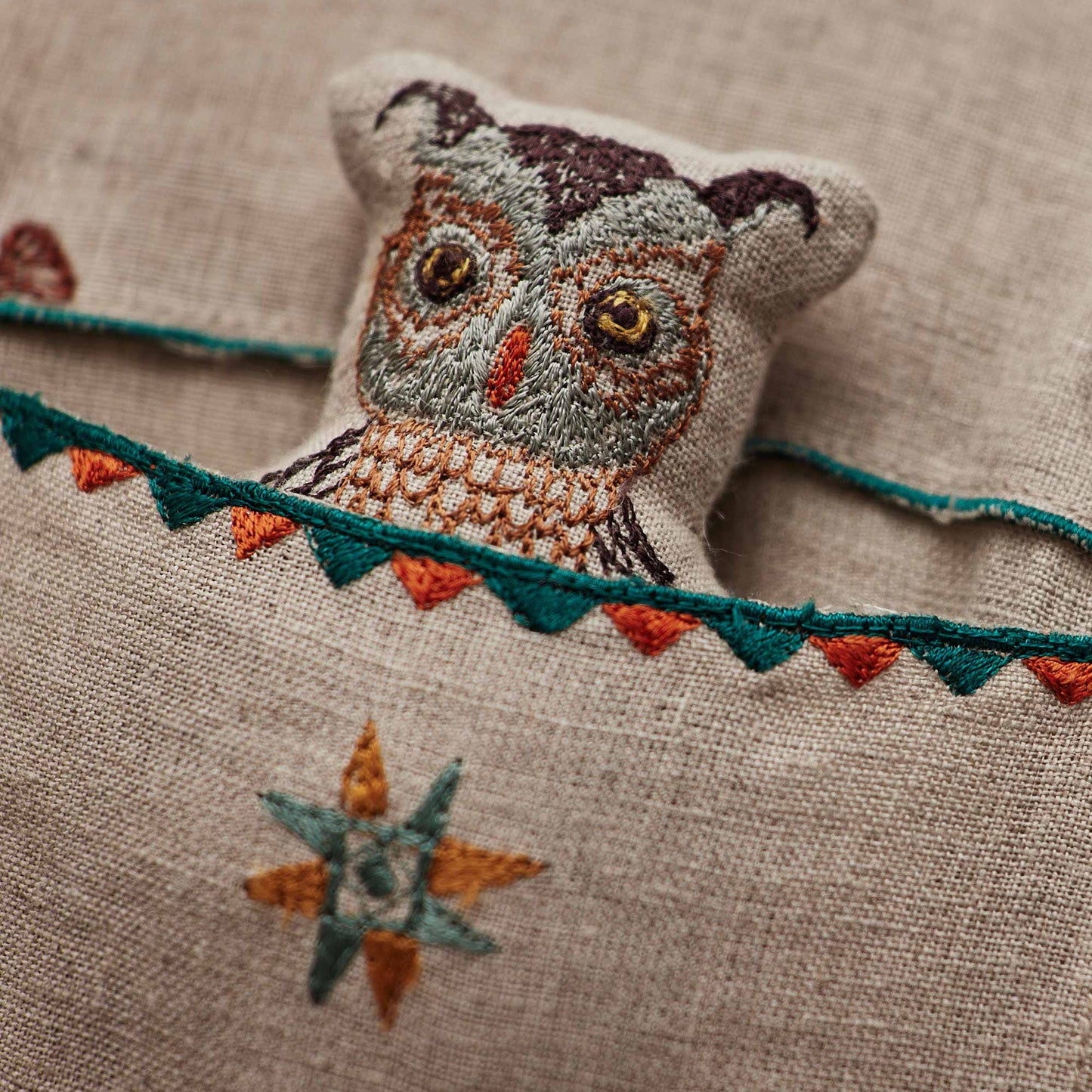 Coral and Tusk’s “Friend’s Canoe” embroidered linen pocket pillow featuring three woodland friends paddling in a canoe, measures 12” x 16”