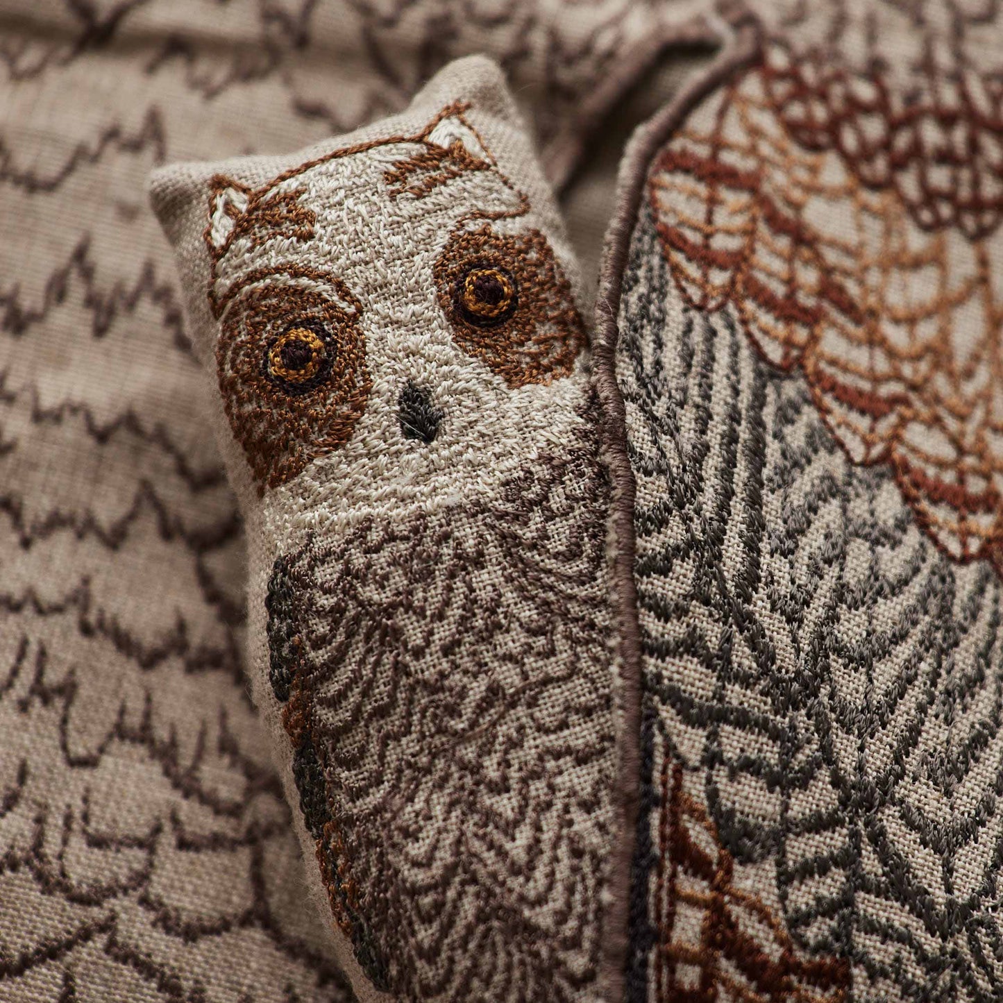 Coral and Tusk’s “Owl Mama” embroidered linen pocket pillow featuring a mother owl with removable owlets under each wing, measures 16” x 16”