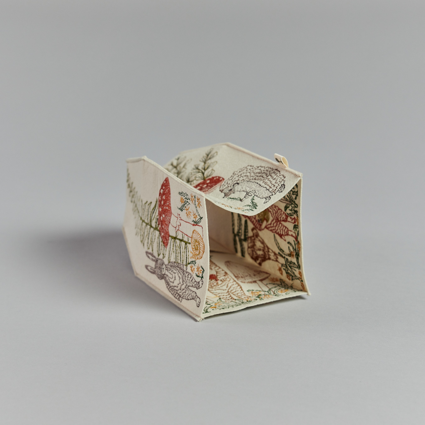 Coral and Tusk's "Mushrooms and Ferns" tissue box cover made of felt and embroidered with animal, mushroom, and fern designs