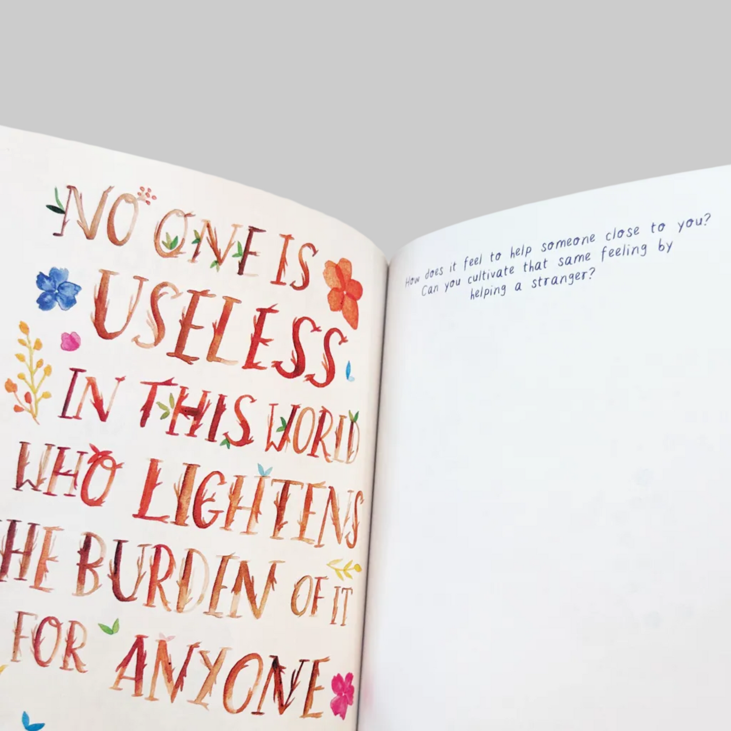 Open book with colorful text and floral decorations on a white background