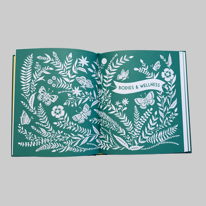 Open page of "This Family of Ours" keepsake journal featuring detailed white illustrations on a green background