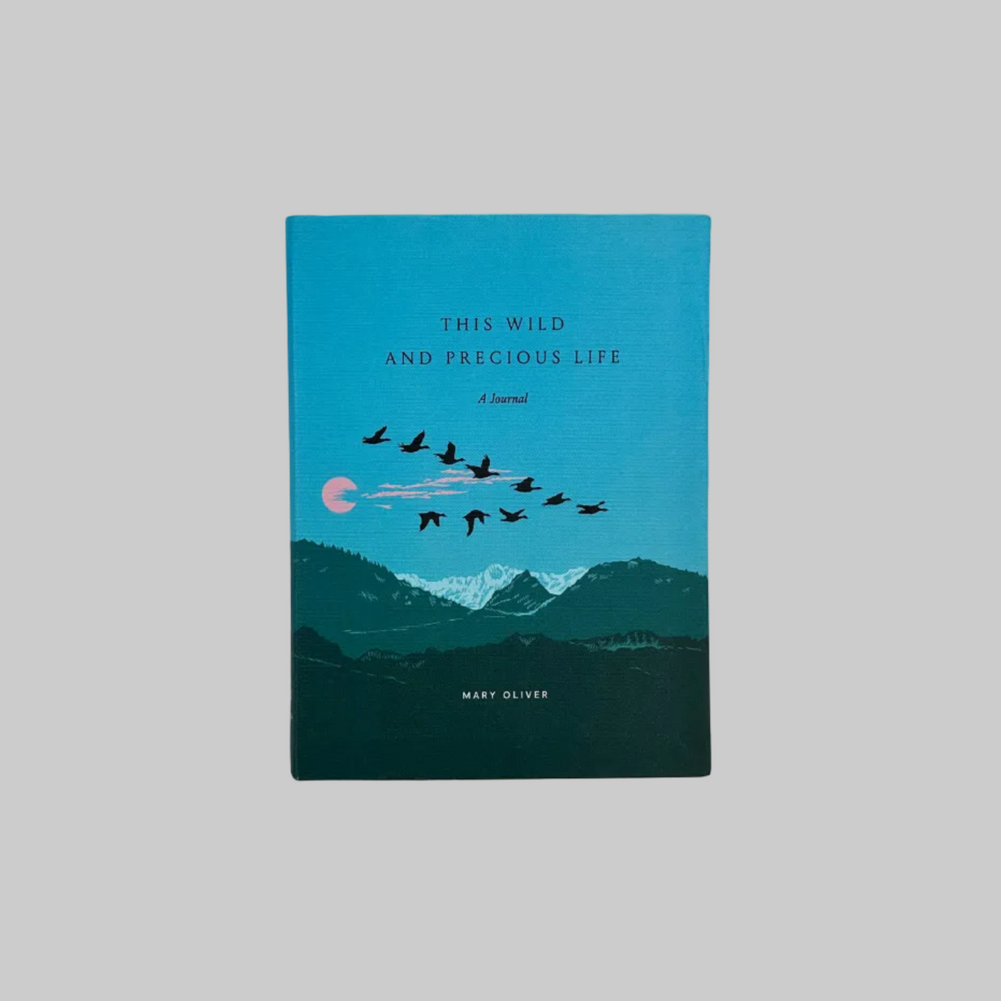 The cover of a journal titled "This Wild and Precious Life," inspired by the poetry of Mary Oliver. The cover design features a serene mountain landscape