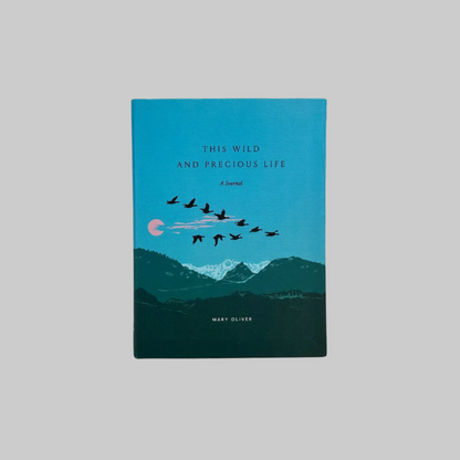 The cover of a journal titled "This Wild and Precious Life," inspired by the poetry of Mary Oliver. The cover design features a serene mountain landscape