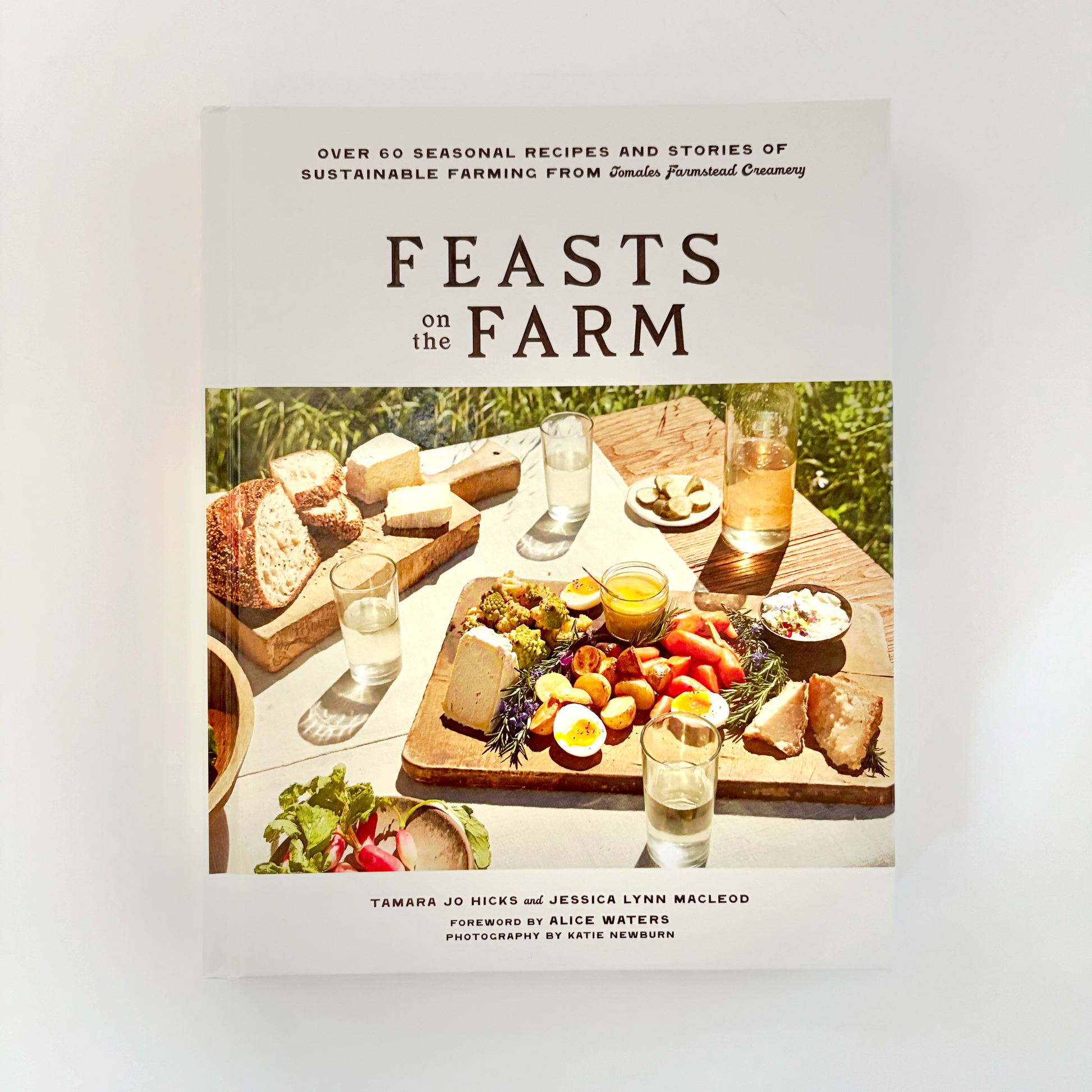 Book cover of 'Feasts on the Farm' with a table setting and food.