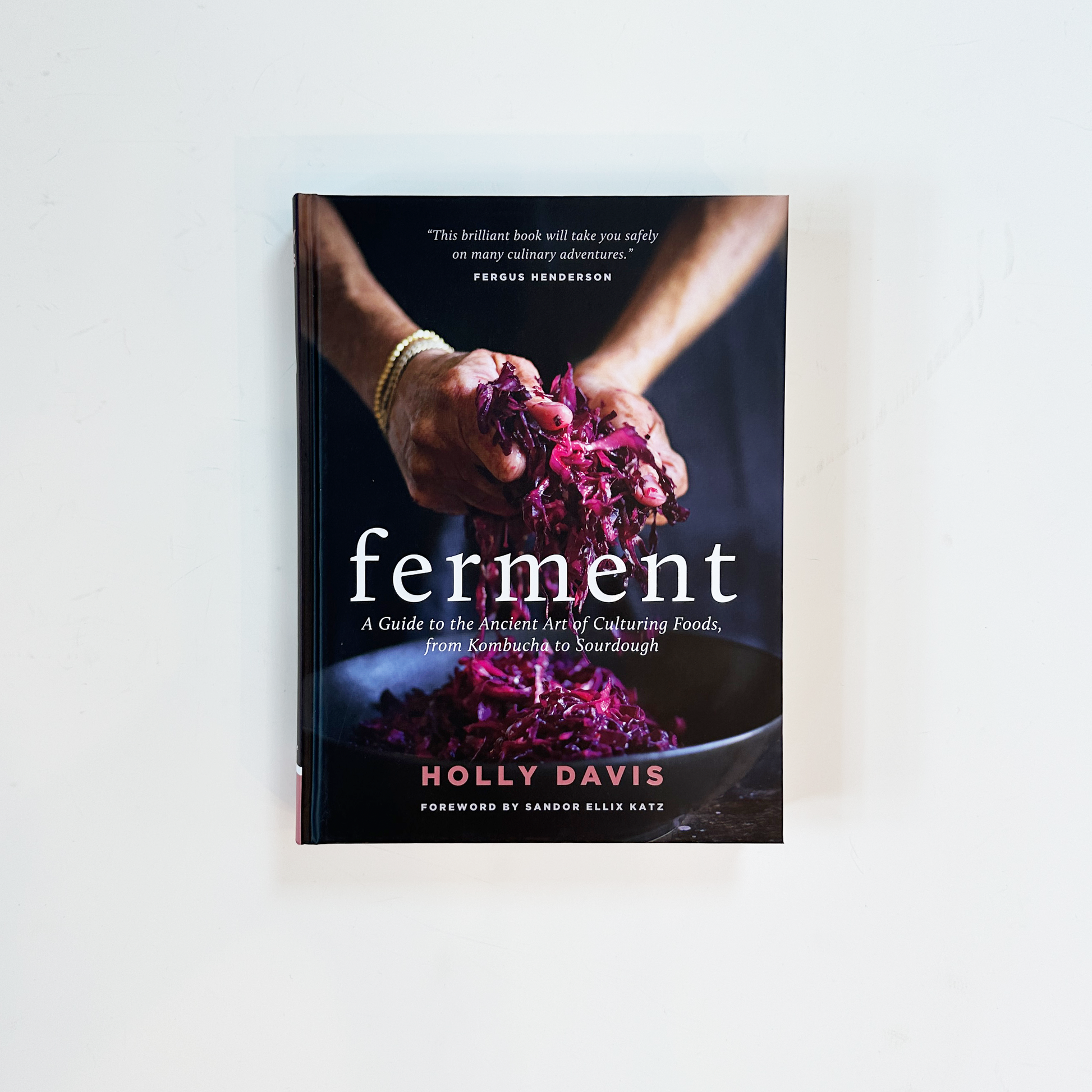 A book titled 'Ferment' by Holly Davis, featuring a cover image of hands holding fermented purple cabbage.