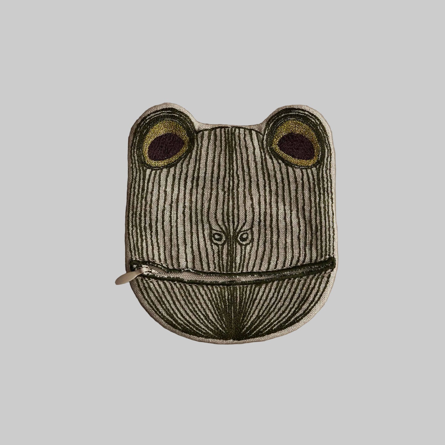 Frog-shaped pouch with a zipper on a beige background