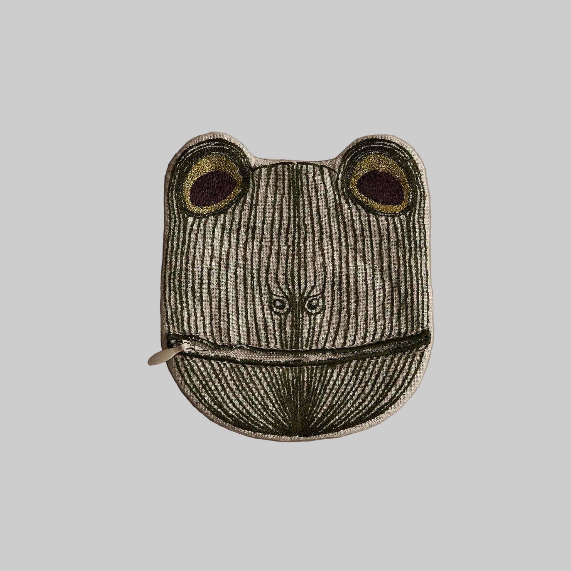 Frog-shaped pouch with a zipper on a beige background