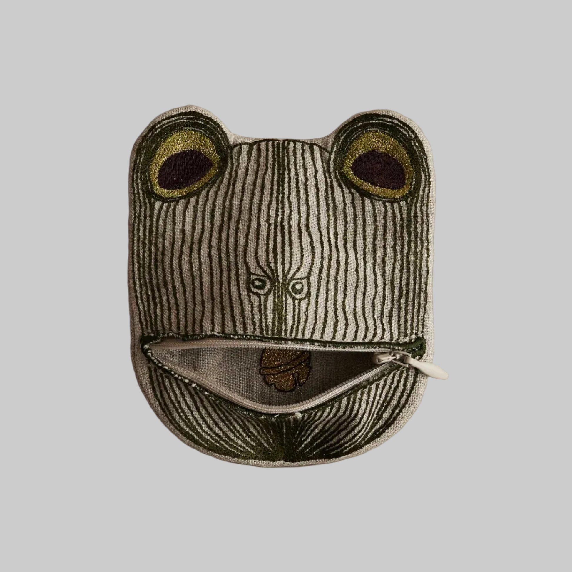 Frog-shaped pouch with a zipper on a beige background