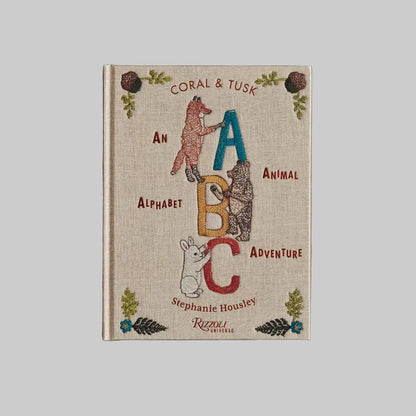 Book titled 'Coral & Tusk: An Alphabet Animal Adventure' by Stephanie Housley on a beige background