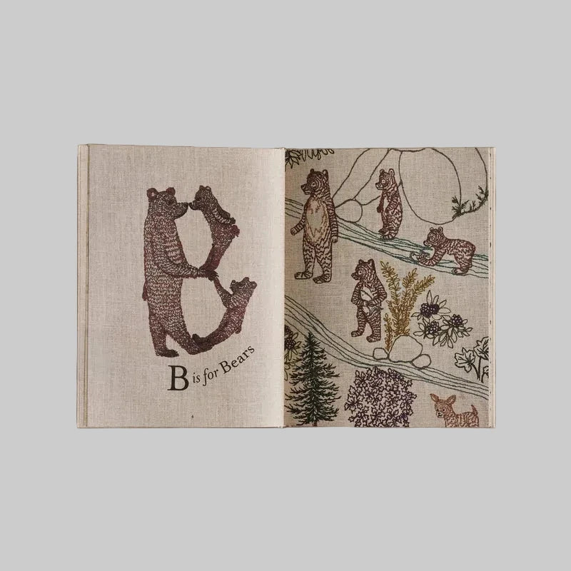 Open page of the Coral and Tusk ABC book with illustrations of bears on a beige background
