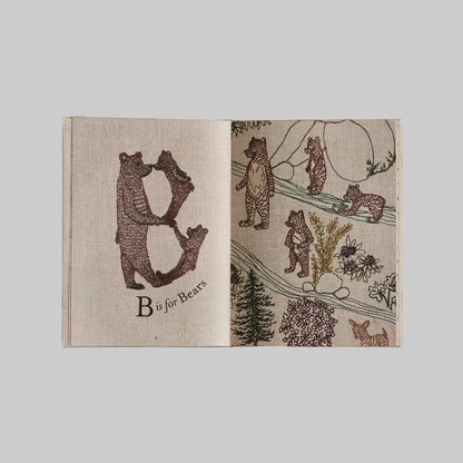 Open page of the Coral and Tusk ABC book with illustrations of bears on a beige background