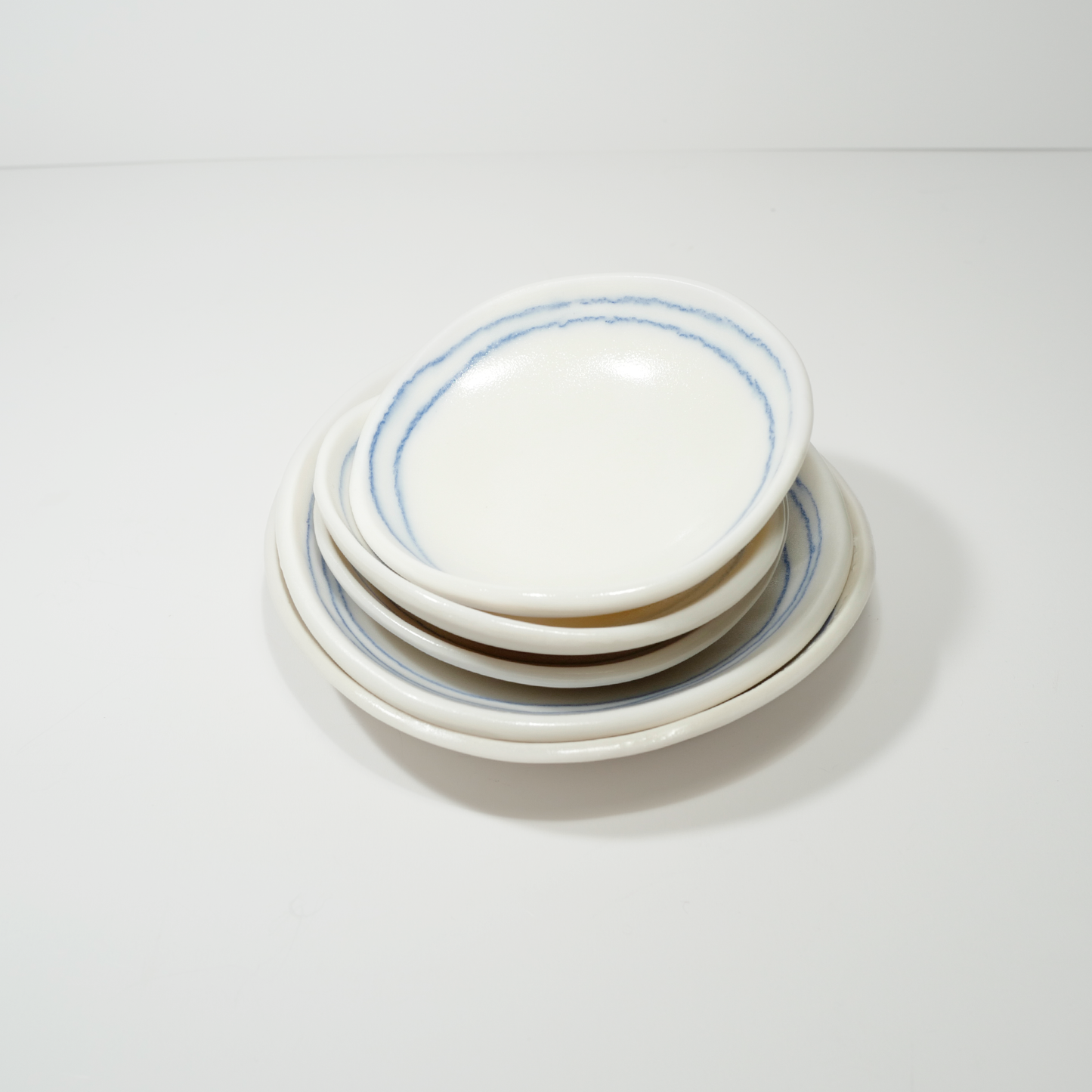 White ceramic dishes with blue line designs, made by Jenny Dowd