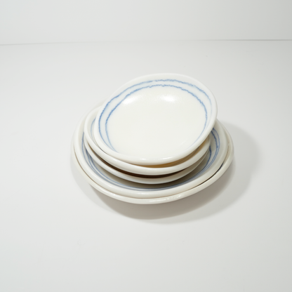 White ceramic dishes with blue line designs, made by Jenny Dowd