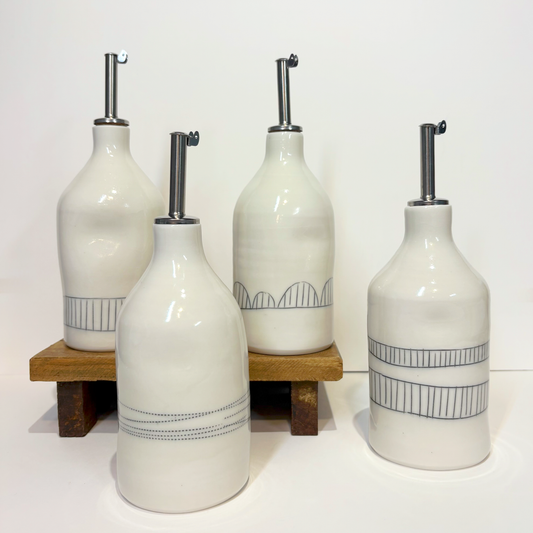 Set of four white oil cruet bottles with silver nozzles