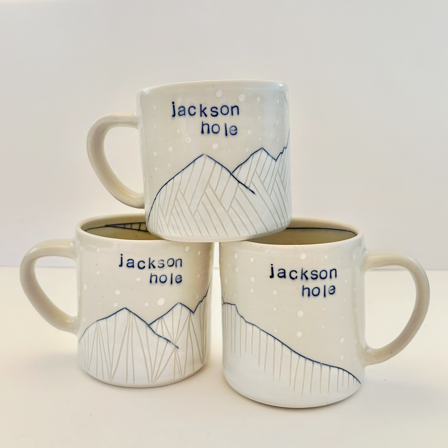 Three white mugs with 'Jackson Hole' text and mountain design