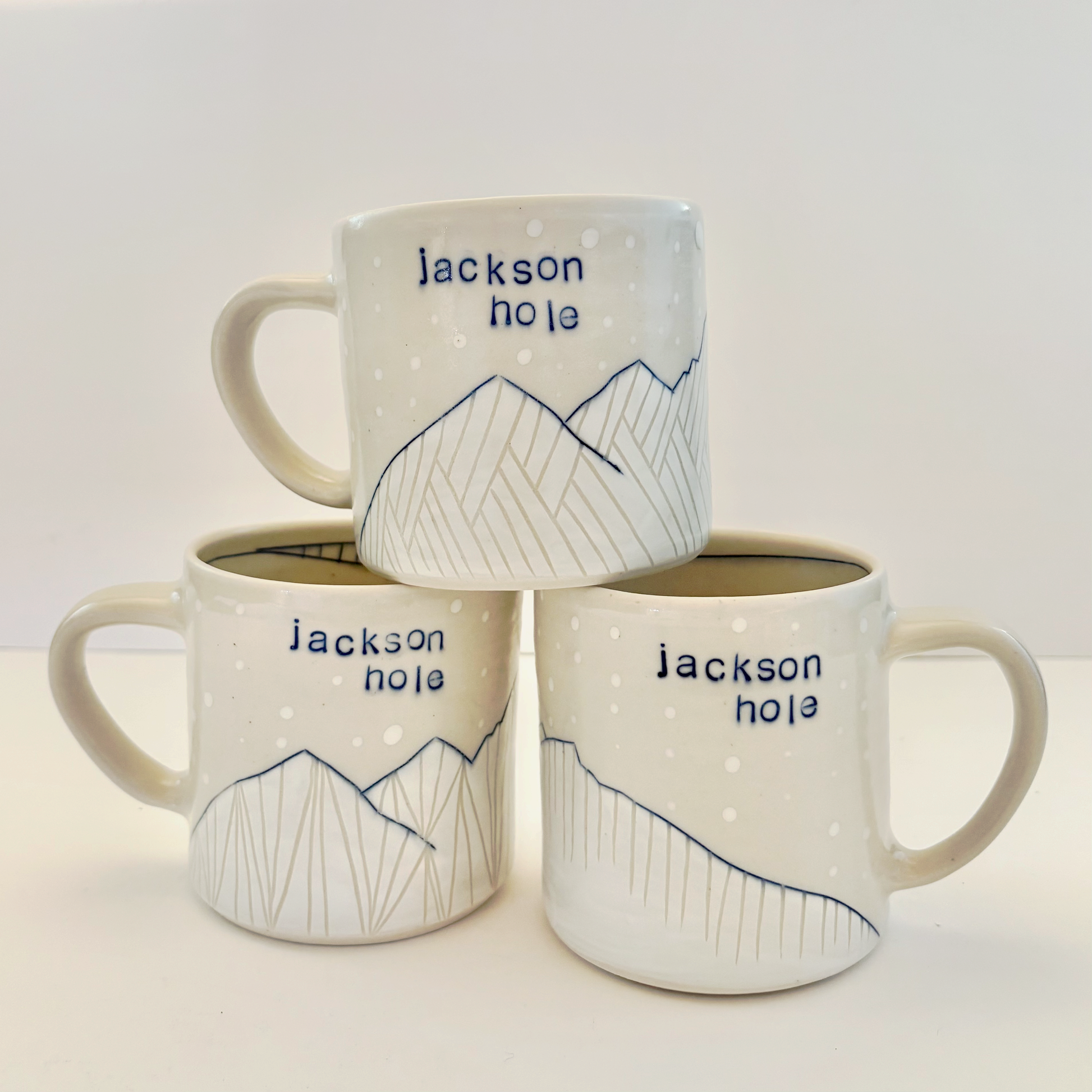 Three white mugs with 'Jackson Hole' text and mountain design