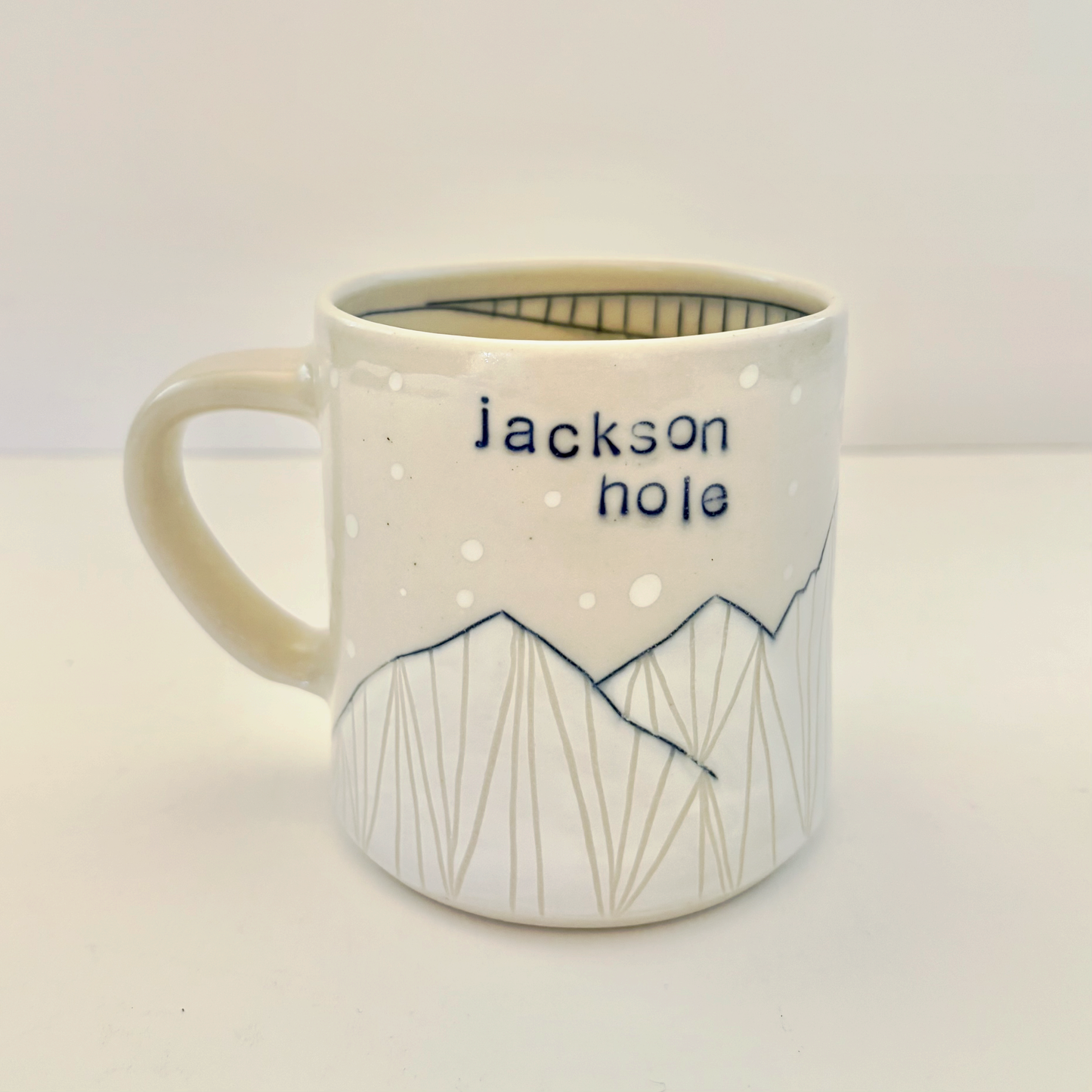 White mug with "jackson hole' text and mountain design