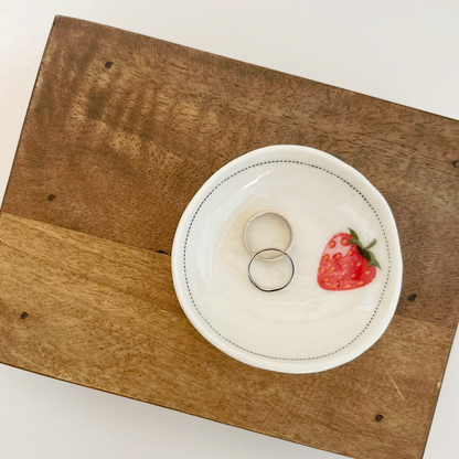 White ceramic dish with black line and strawberry design