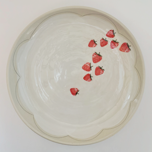 Decorative serving platter with red strawberry pattern on a white background