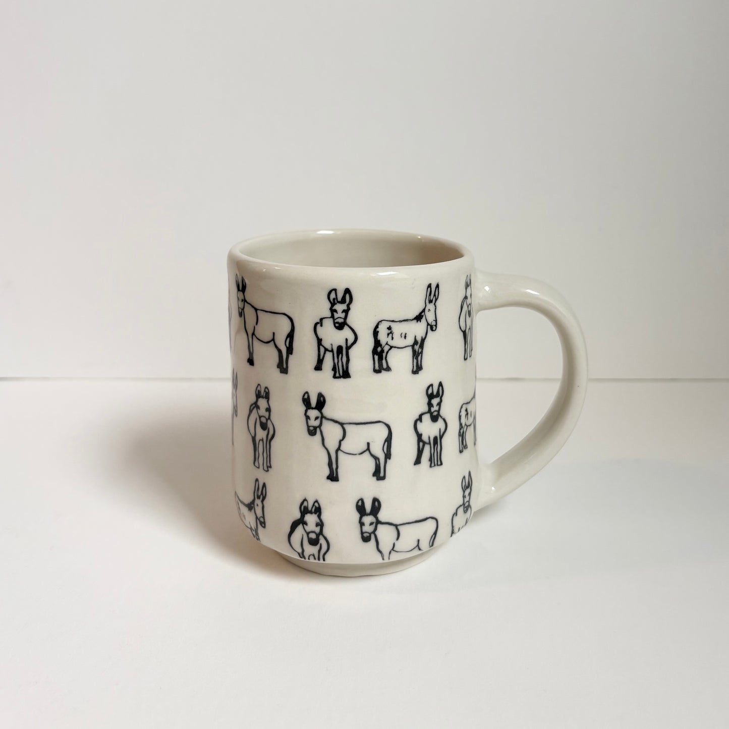 White mug with black donkey designs