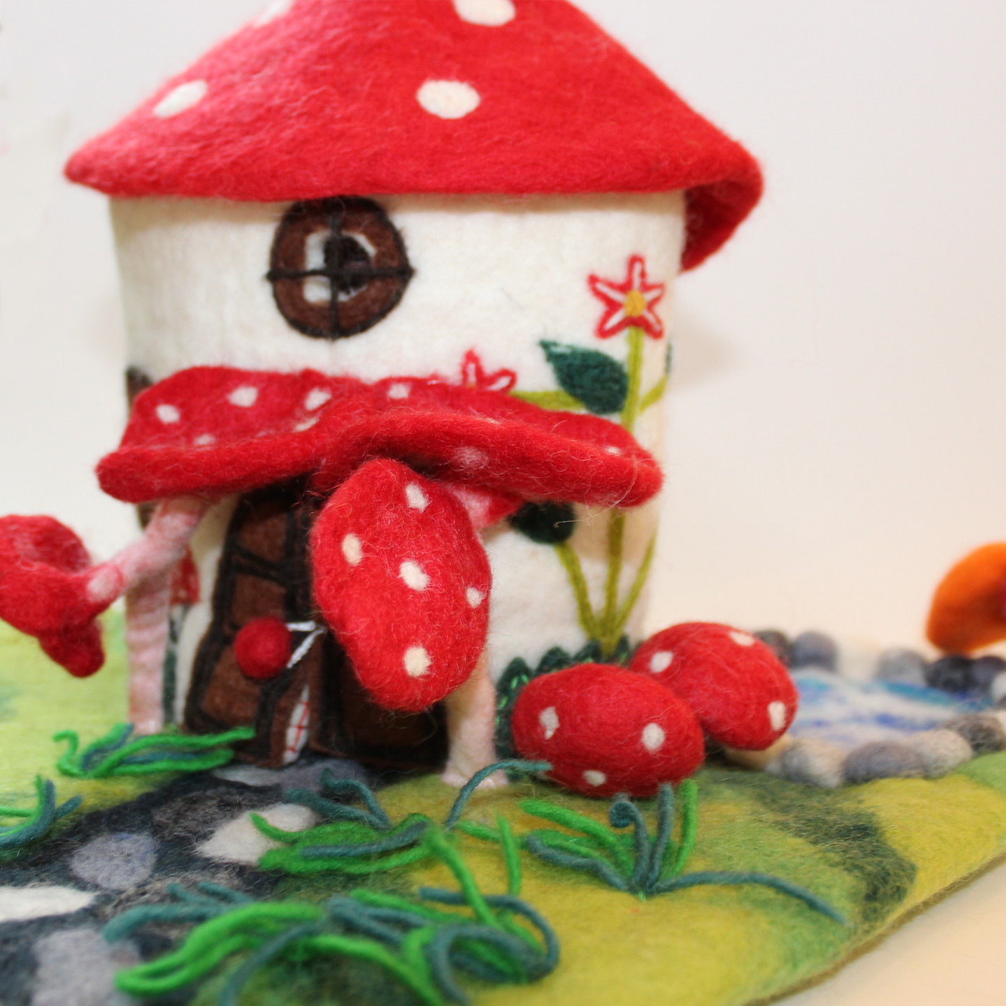 Felted fairy house decorated with red mushrooms from The Winding Road