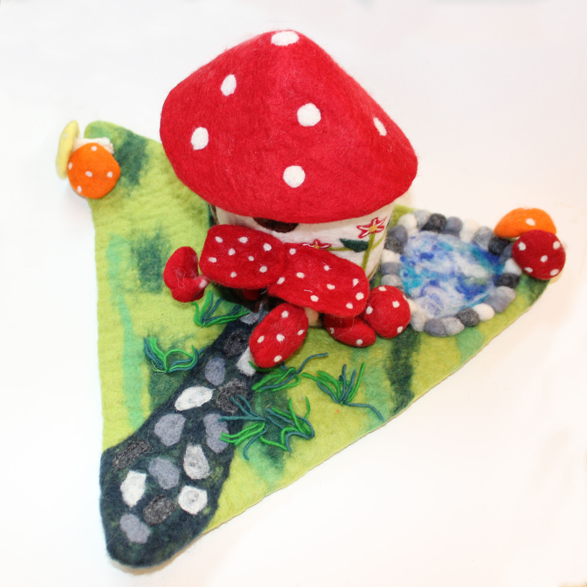Felted fairy house decorated with red mushrooms from The Winding Road
