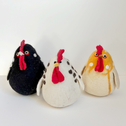 Three colorful felted chicken figurines on a white background
