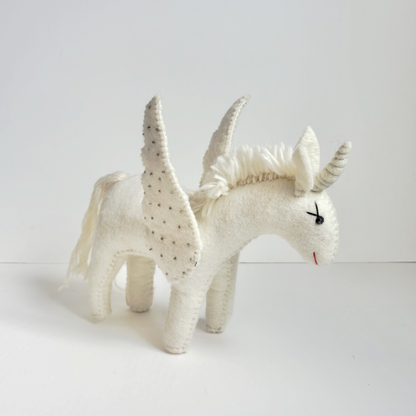 White unicorn toy with jeweled spots on a white background