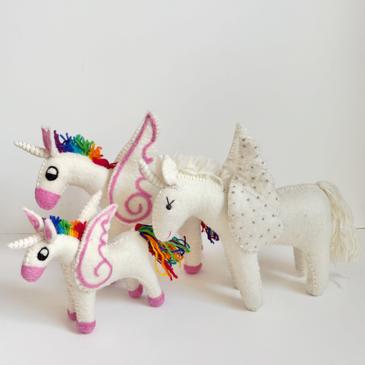 Three unicorn toys with colorful designs on a white background