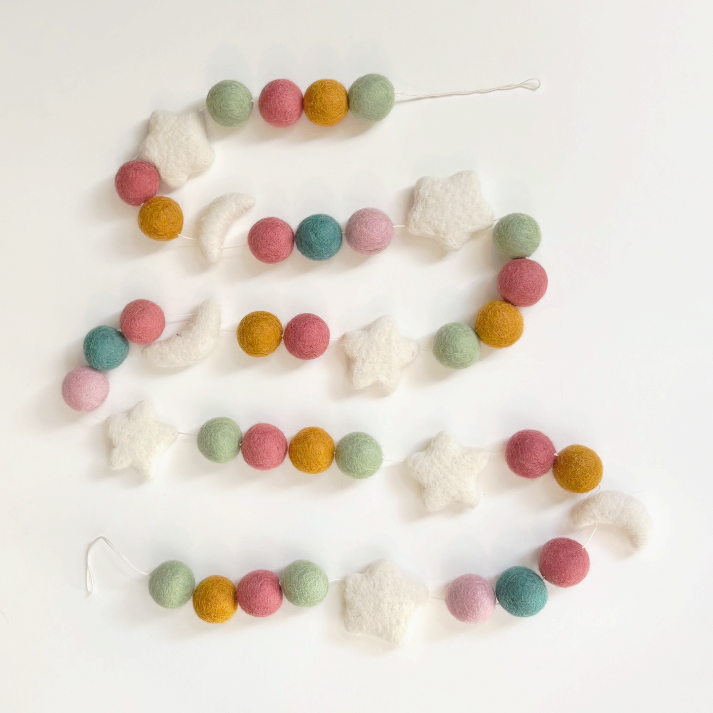 Garland made of pastel-colored felted beads and white stars and moons