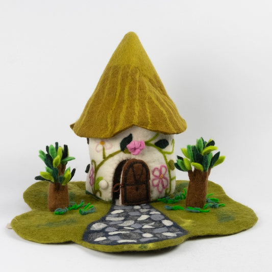 Felt cottage-style fairy house with a pointed green roof and small trees from The Winding Road