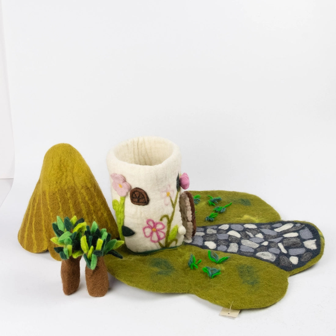 Felt cottage-style fairy house with a pointed green roof and small trees from The Winding Road