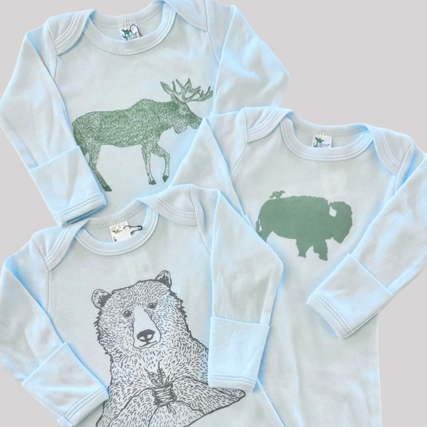 Bird and Buffalo’s baby gowns in blue featuring various designs, made locally in Jackson Hole, WY