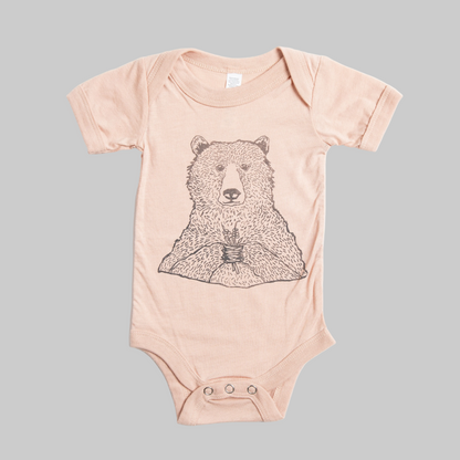 Bird and Buffalo’s baby onesie in pink with a bear holding flowers design, made locally in Jackson Hole, WY