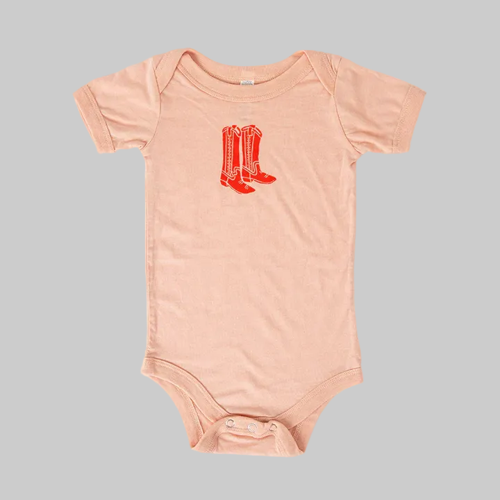 Bird and Buffalo’s baby onesie in pink with a red boots design, made locally in Jackson Hole, WY