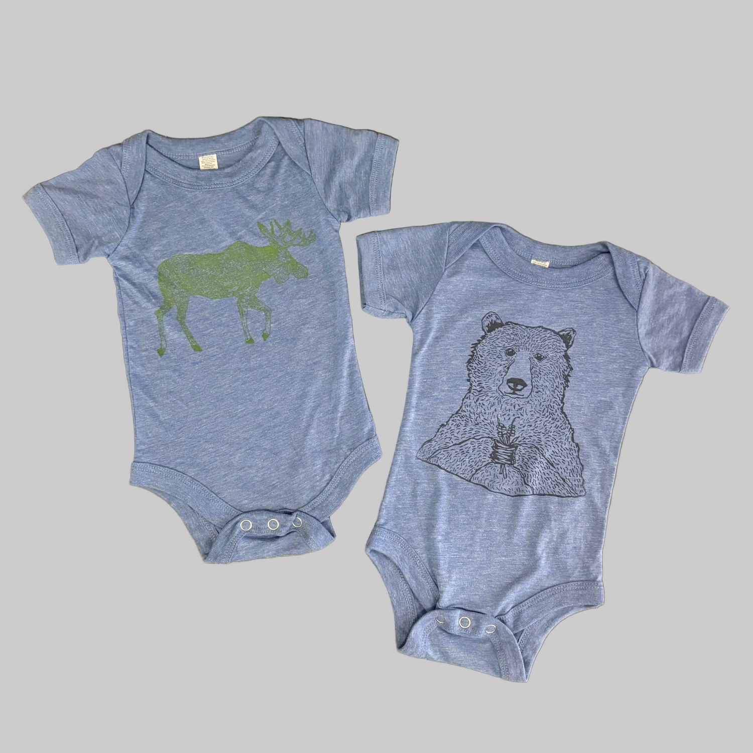 Bird and Buffalo’s baby onesie in blue with screen printed designs, made locally in Jackson Hole, WY