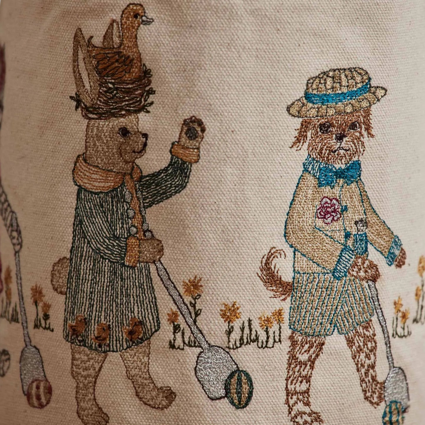 Coral and Tusk’s “Easter Egg Roll” embroidered canvas bag, featuring animals in vintage clothing rolling Easter eggs