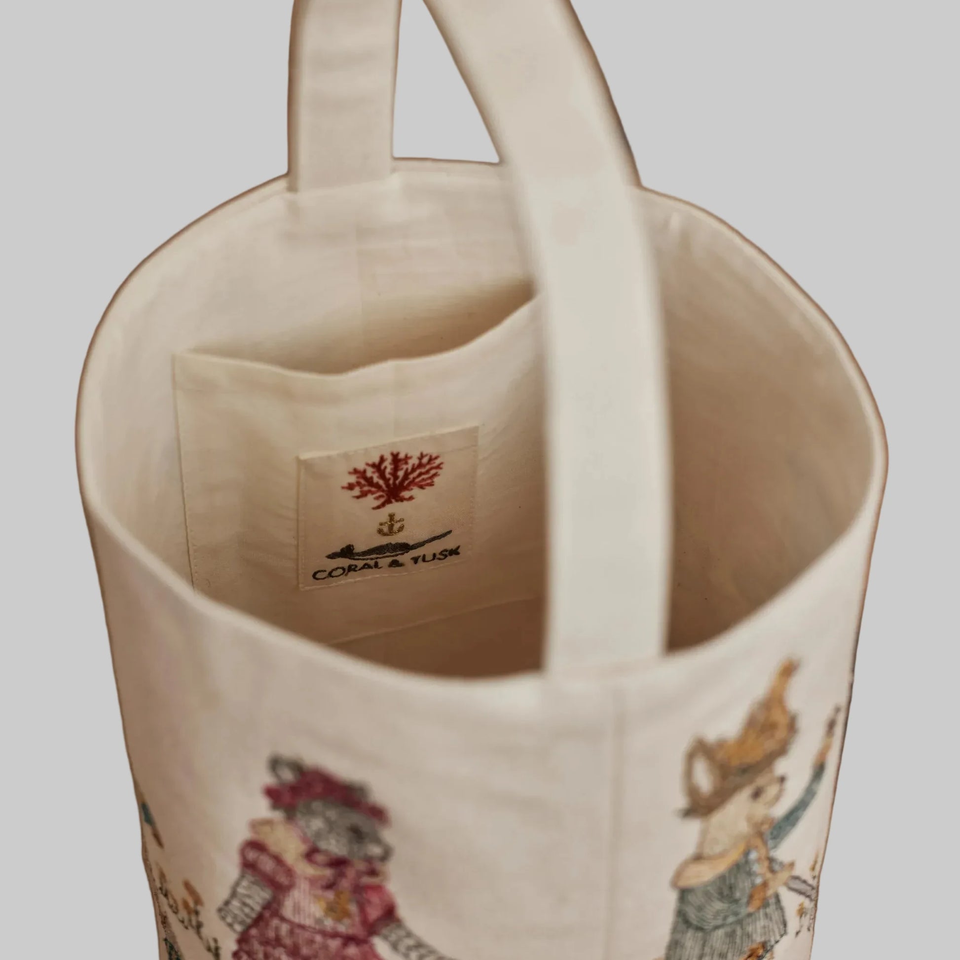 Coral and Tusk’s “Easter Egg Roll” embroidered canvas bag, featuring animals in vintage clothing rolling Easter eggs