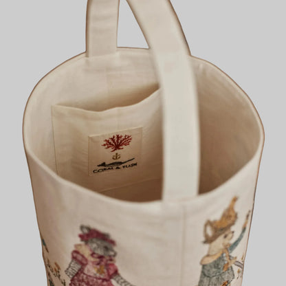 Coral and Tusk’s “Easter Egg Roll” embroidered canvas bag, featuring animals in vintage clothing rolling Easter eggs