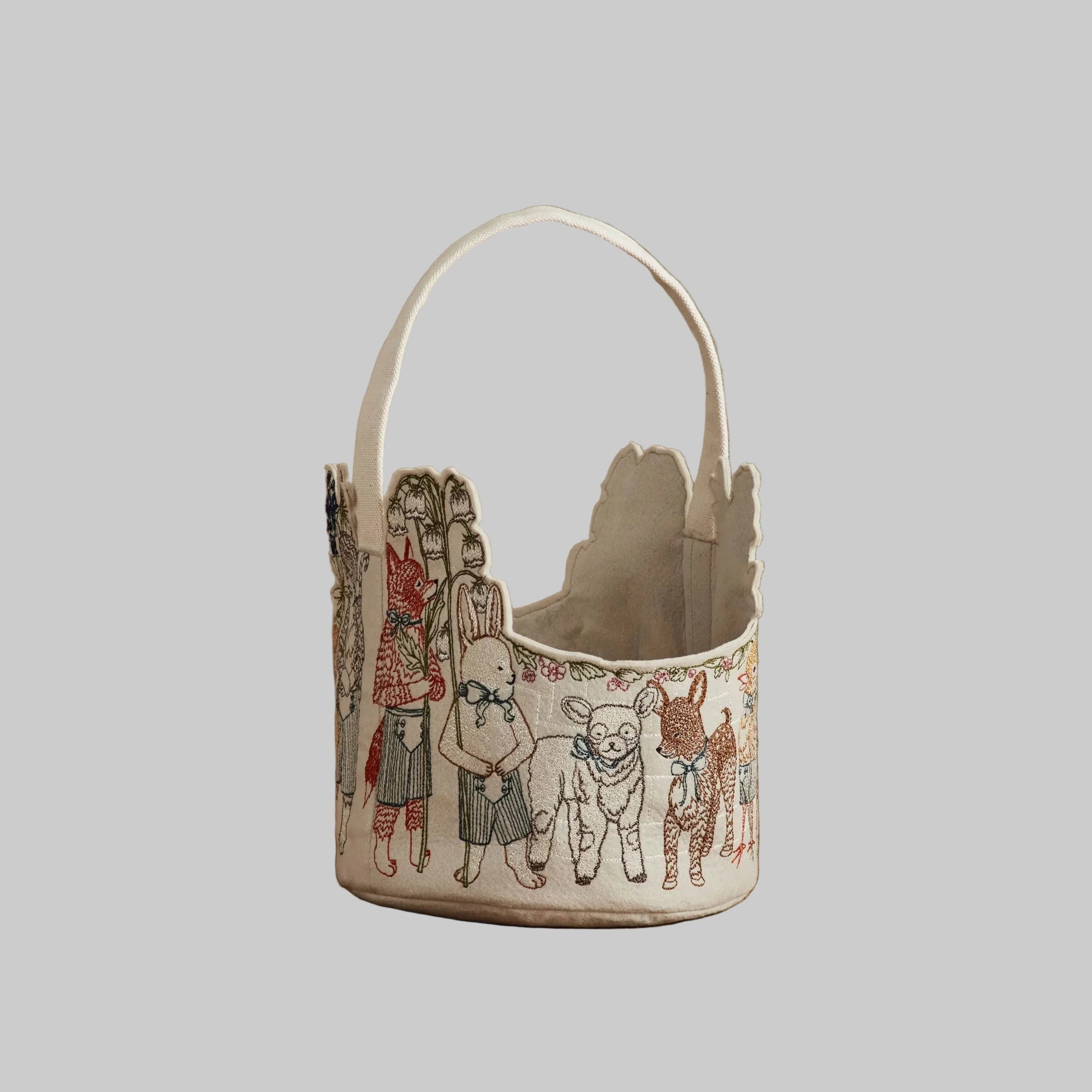 Coral and Tusk’s “Spring Parade” embroidered felt Easter basket, featuring animal friends carrying lilies and bluebonnets