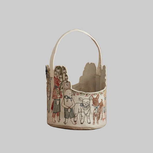 Coral and Tusk’s “Spring Parade” embroidered felt Easter basket, featuring animal friends carrying lilies and bluebonnets
