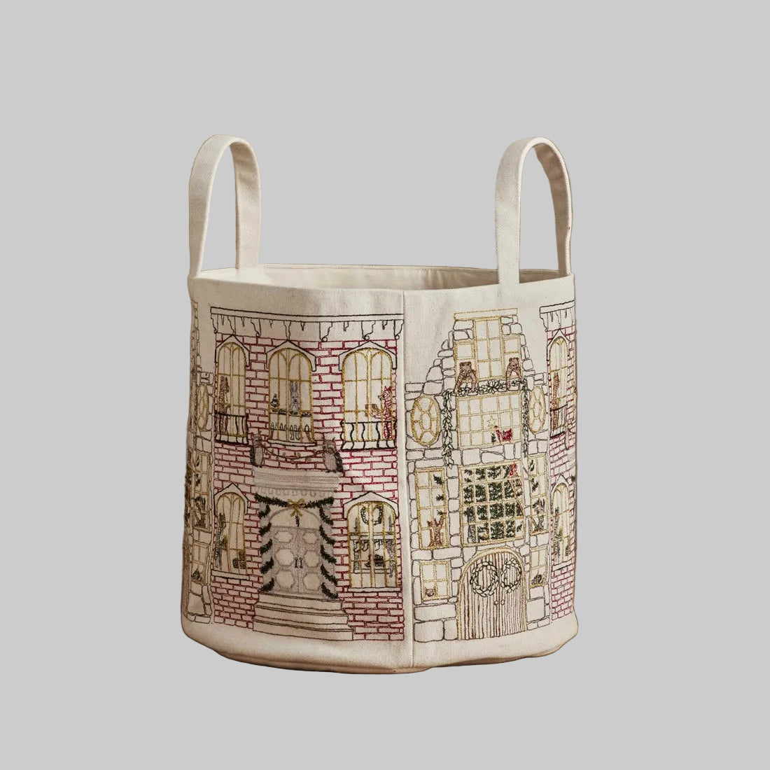 Coral and Tusk's "Home For the Holidays" embroidered canvas bucket featuring intricate designs of woodland friends decorating their city home