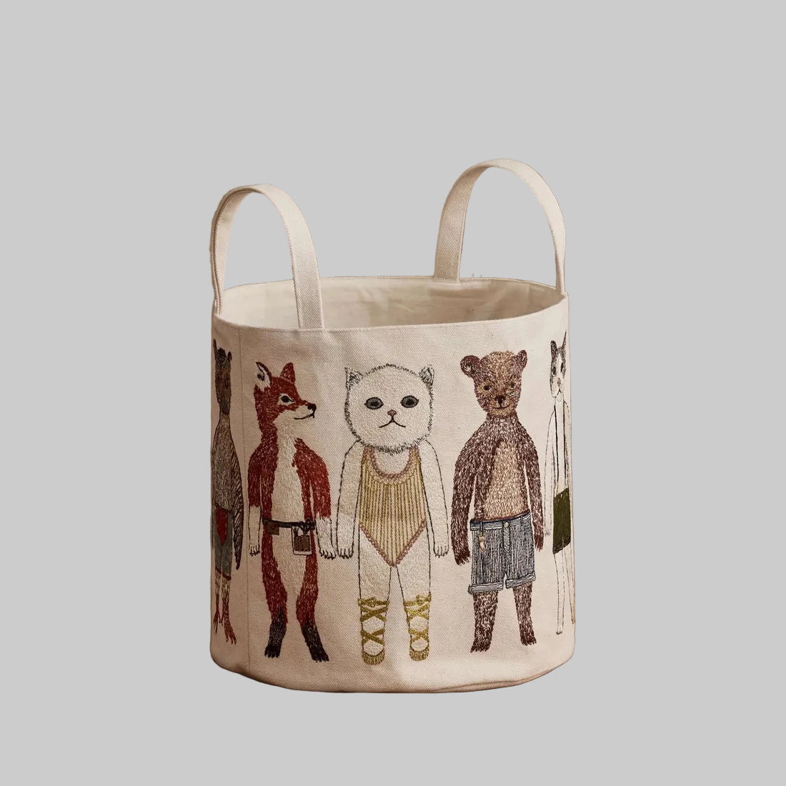 Coral and Tusk's "Pocket Doll" canvas bucket bag featuring embroidered designs of animal friends in fanciful clothing
