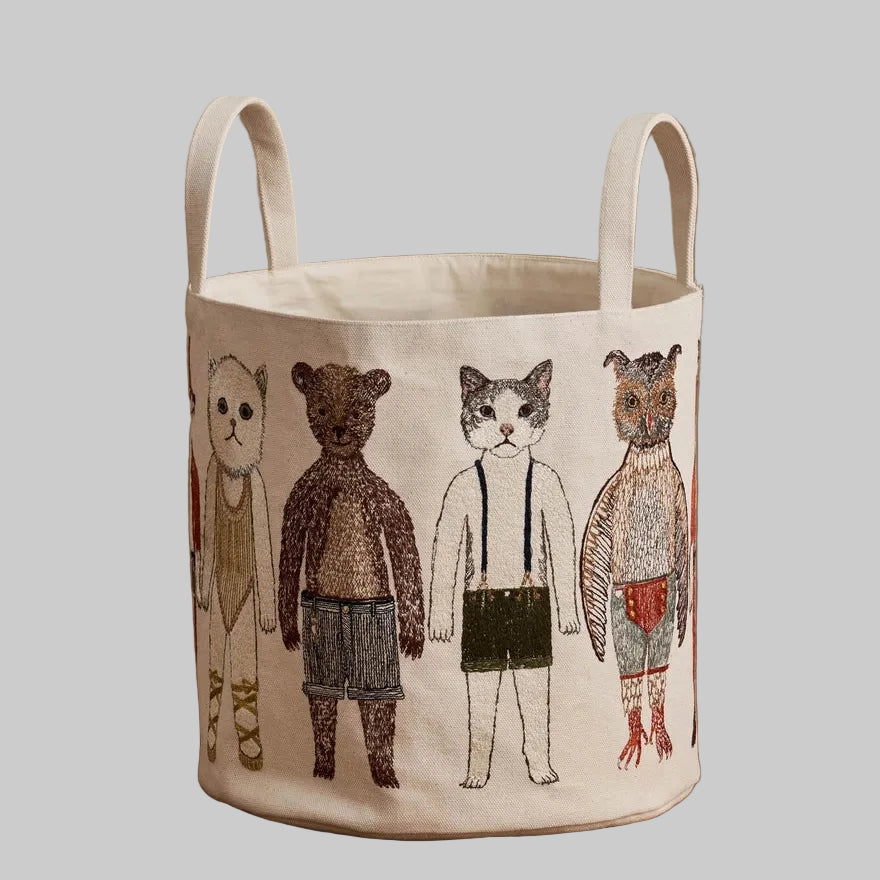 Coral and Tusk's "Pocket Doll" canvas bucket bag featuring embroidered designs of animal friends in fanciful clothing