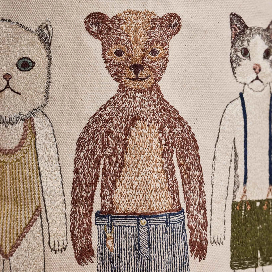 Coral and Tusk's "Pocket Doll" canvas bucket bag featuring embroidered designs of animal friends in fanciful clothing